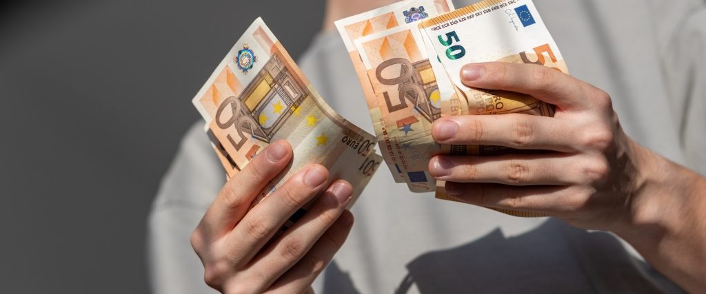 Mains comptant des billets de cinquante euros de la première série