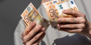Mains comptant des billets de cinquante euros de la première série