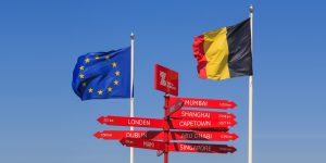 Drapeaux de l'Union européenne et de la Belgique encadrant un panneau indicateur maritime